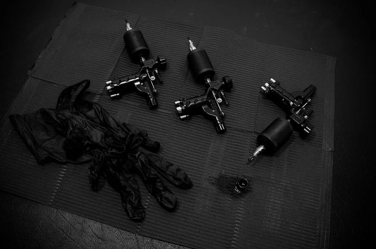 Close-up view of tattoo machines ink caps and sterile supplies arranged on a studio tray conveying professional setup